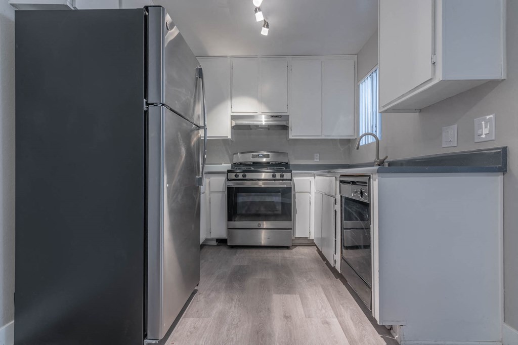 a kitchen with white cabinets and stainless steel appliances