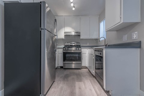 a kitchen with white cabinets and stainless steel appliances