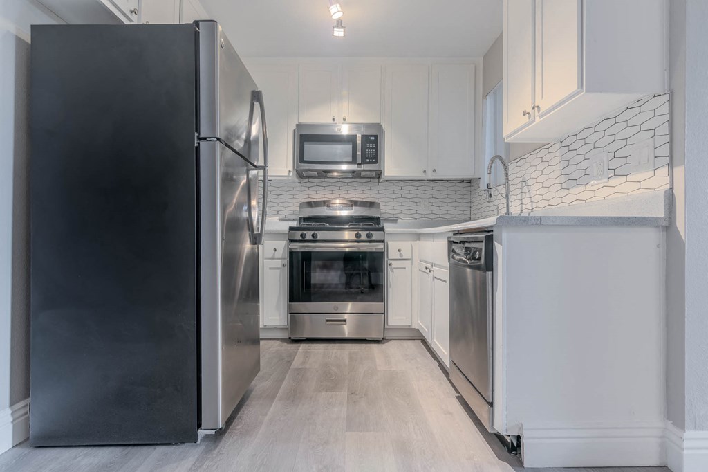 a kitchen with stainless steel appliances and white cabinets