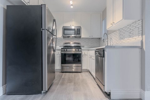 a kitchen with stainless steel appliances and white cabinets