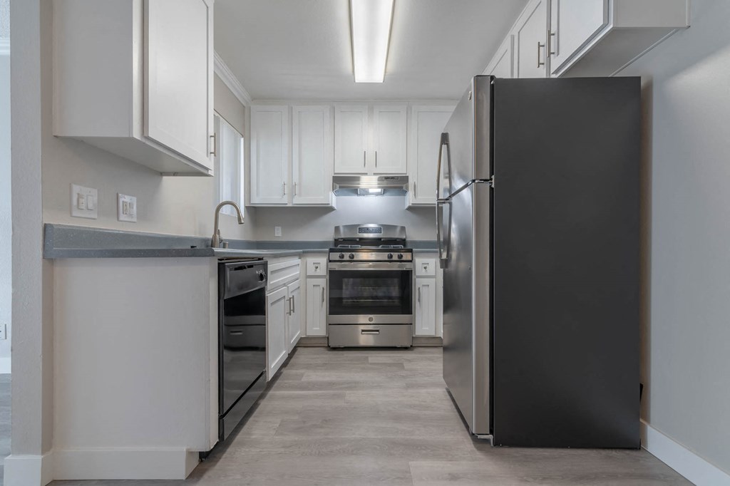 a kitchen with white cabinets and stainless steel appliances