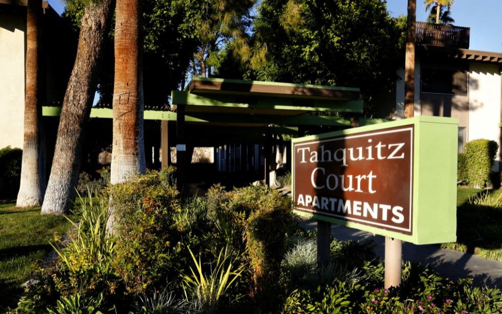 a sign for the court apartments in front of a building