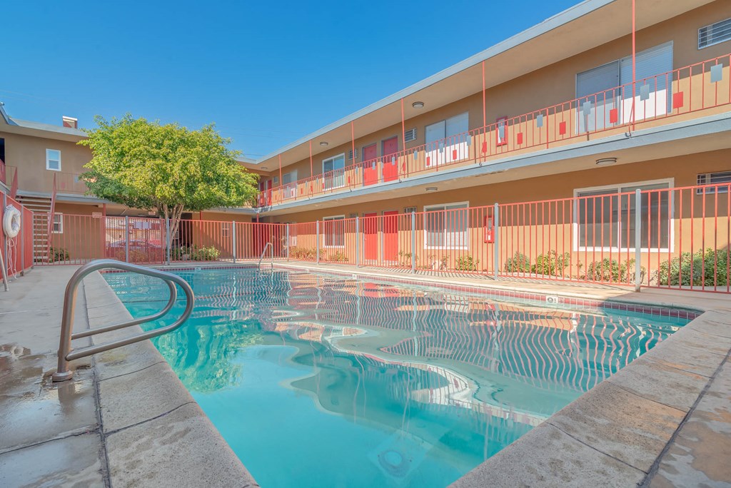a swimming pool in front of a building with a resort style pool