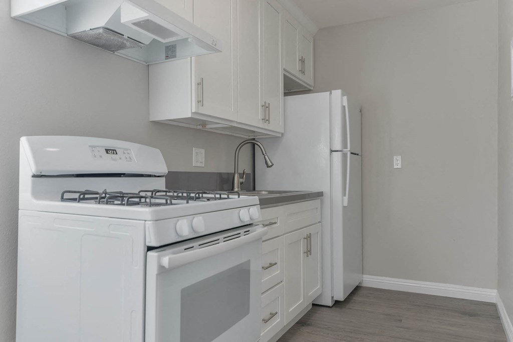 a white kitchen with white appliances and a refrigerator