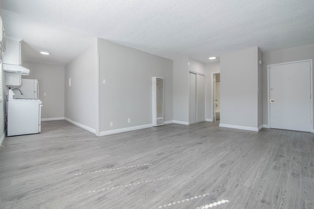 an empty living room with white walls and wood floors