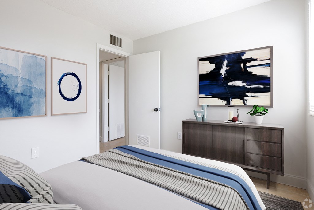 a bedroom with white walls and a blue and white striped bedspread