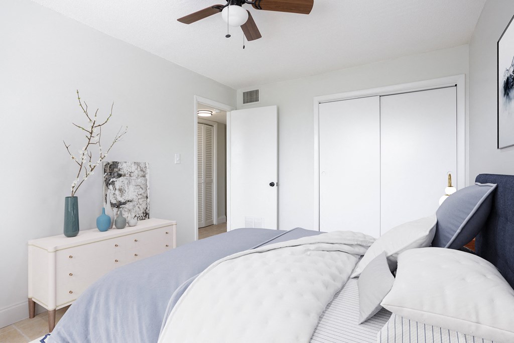 a bedroom with white walls and a ceiling fan