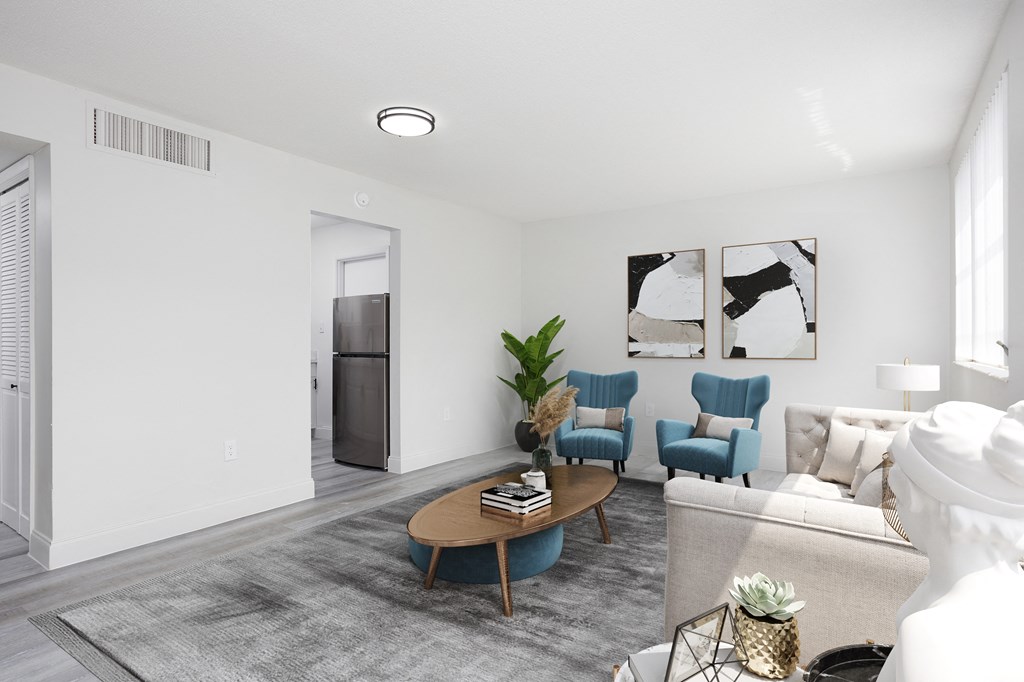 a living room with white walls and a gray carpet
