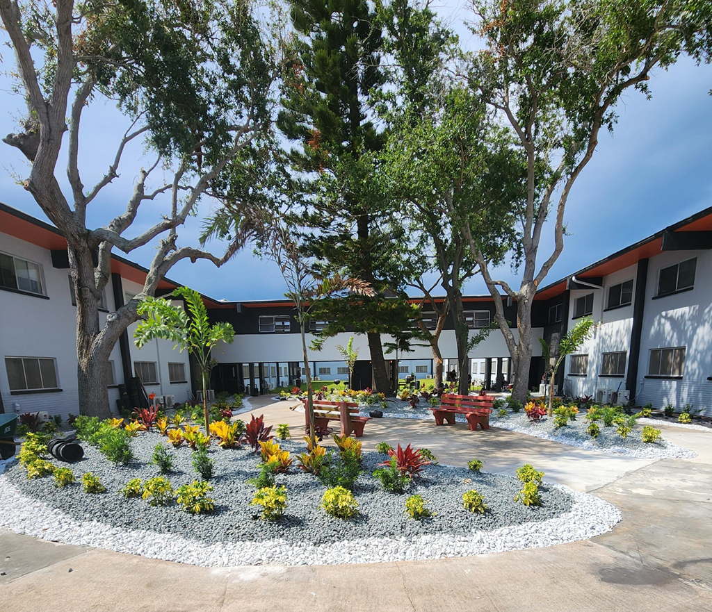 a courtyard with trees and benches in front of a building