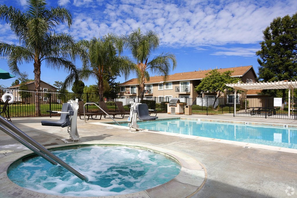 a swimming pool with trees and a building in the background