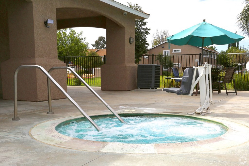 a jacuzzi in the pool of a house with an umbrella