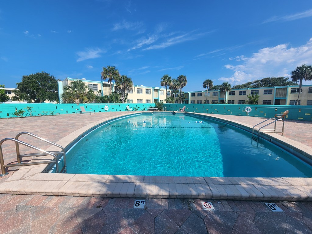 a large swimming pool with a blue sky in the background