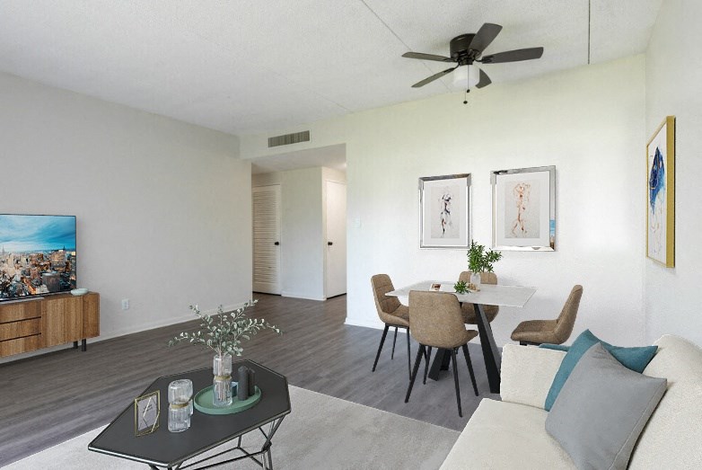a living room and dining room with white walls and a ceiling fan