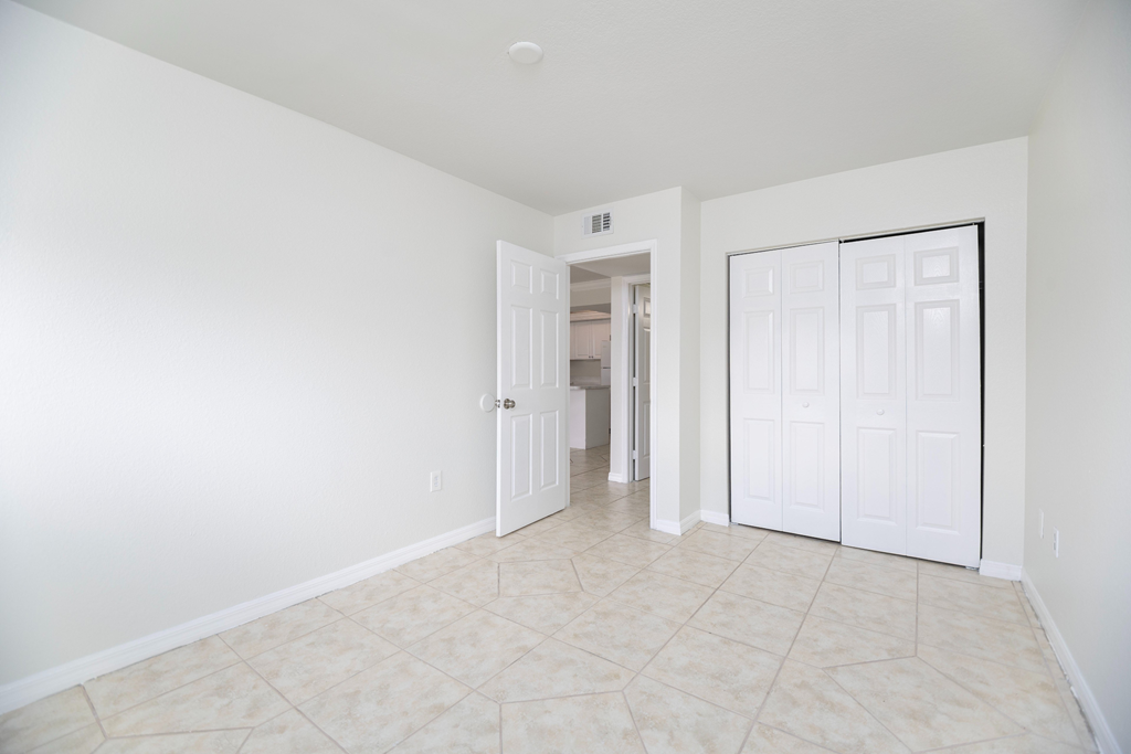 a bedroom with two doors and a tiled floor