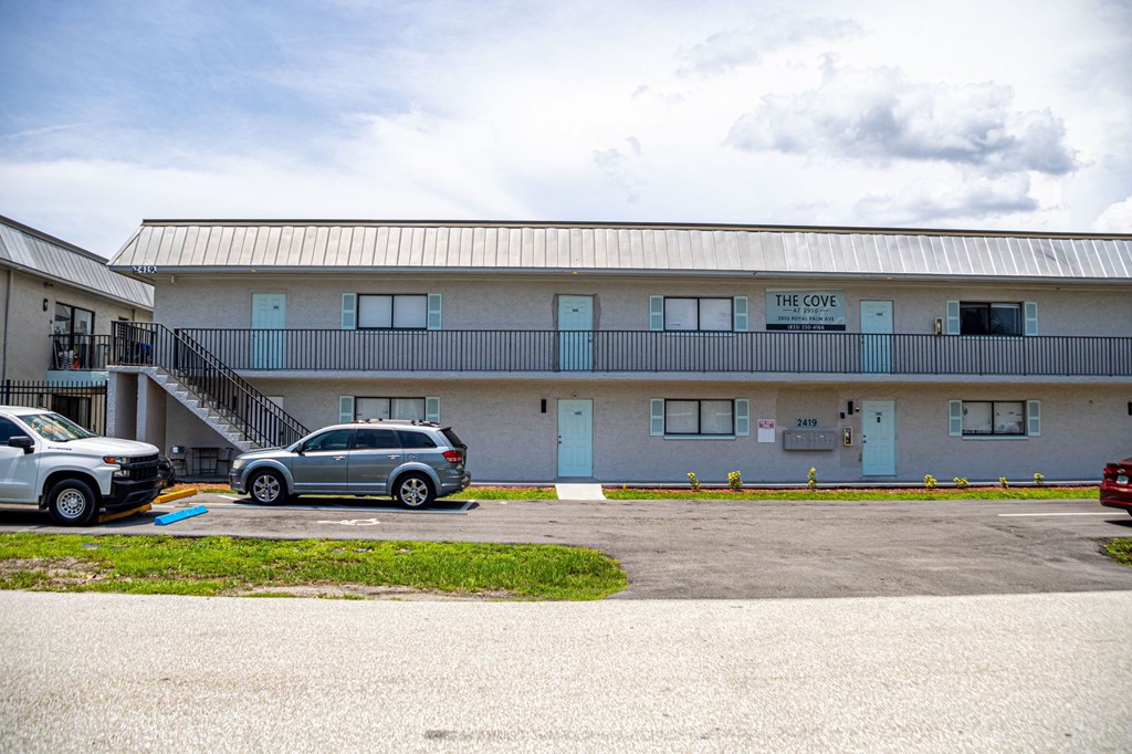 a building with a metal roof and a parking lot in front of it