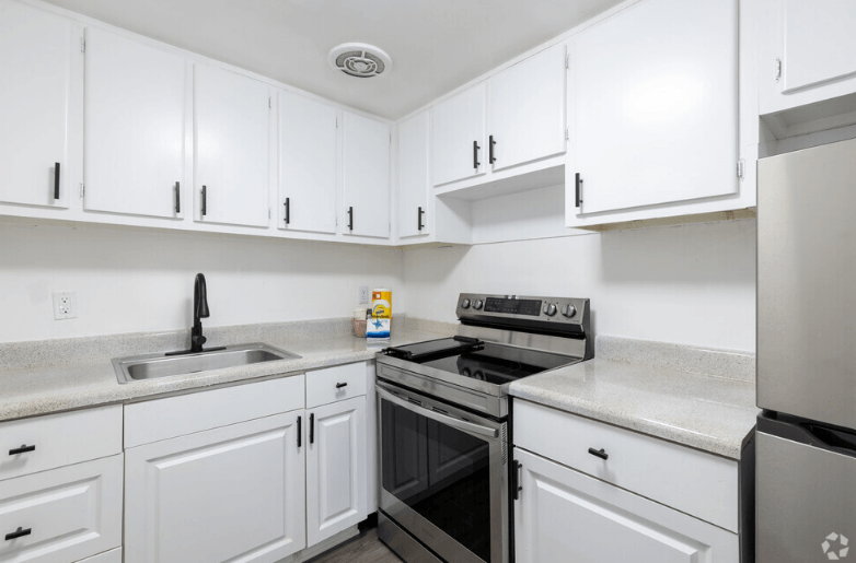 a kitchen with white cabinets and stainless steel appliances