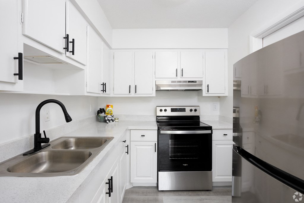 a kitchen with white cabinets and stainless steel appliances