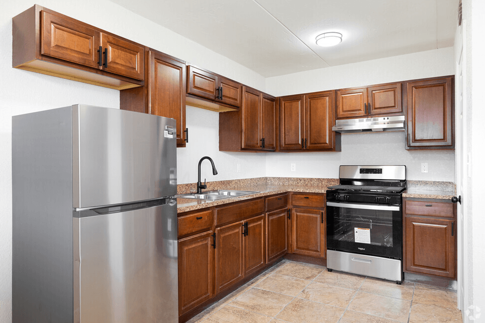 a kitchen with wooden cabinets and stainless steel appliances