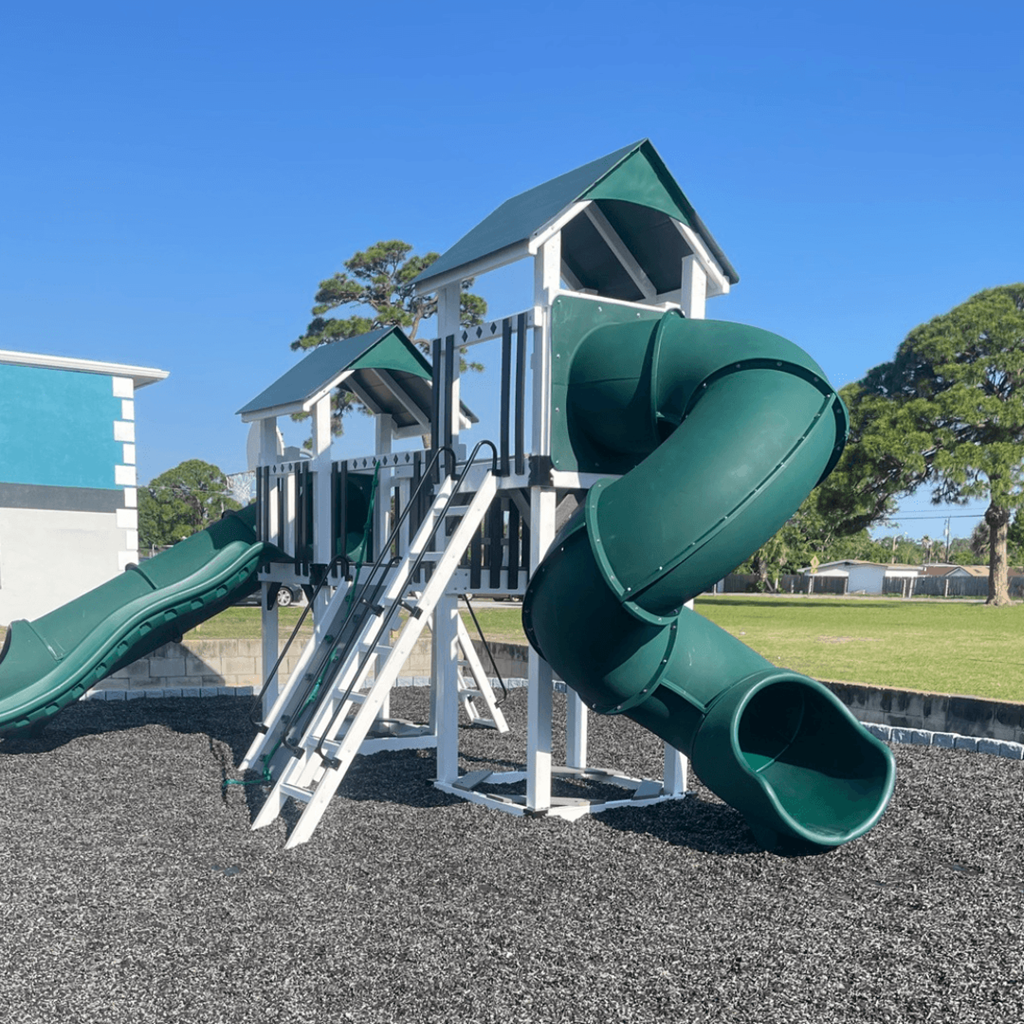 a playground with two slides and a climbing structure