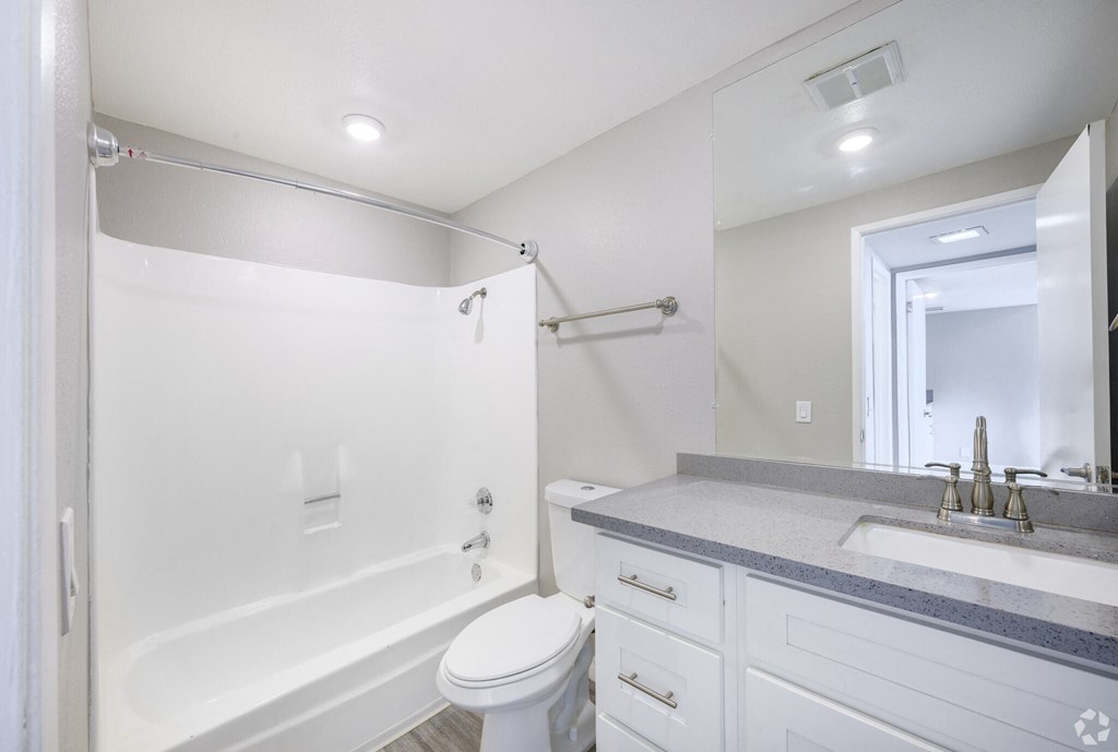 A white bathroom with a toilet, sink, and bathtub.
