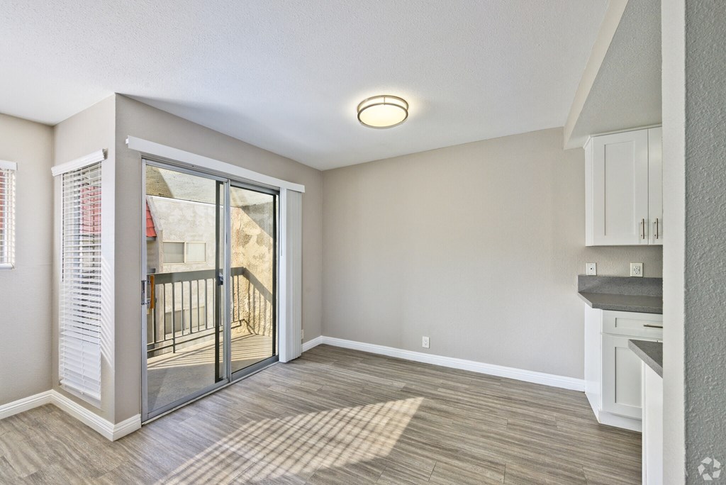 A room with a sliding glass door leading to a balcony.