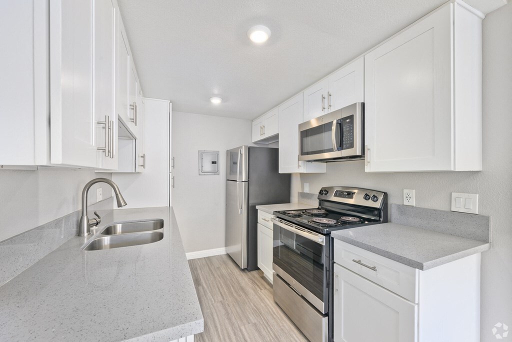 A kitchen with white cabinets and stainless steel appliances.