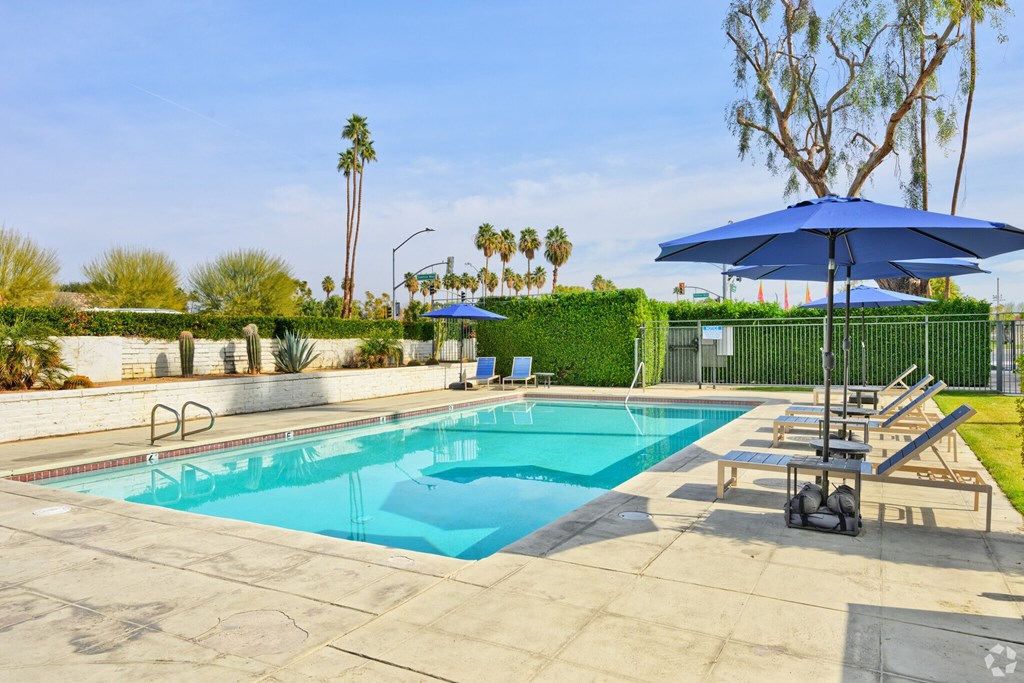 A blue umbrella is next to a pool.