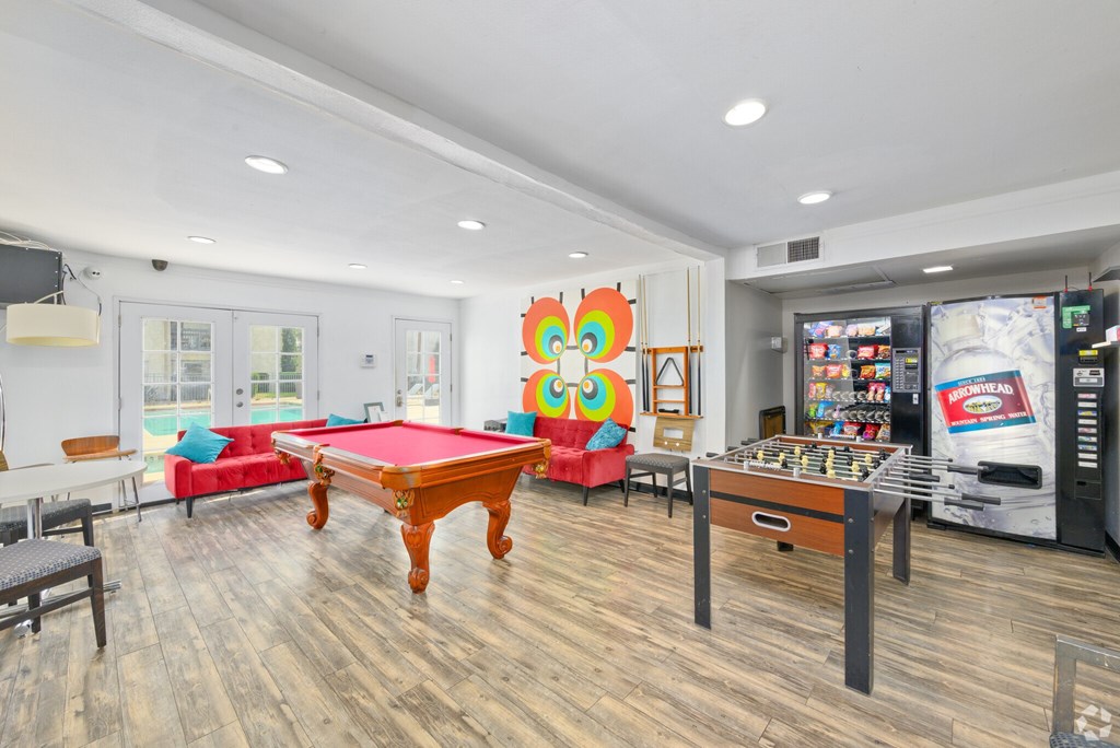 A room with a pool table and a pinball machine.