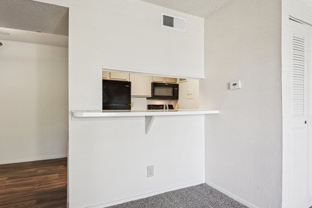 A white kitchen with a microwave and oven built into the cabinetry.