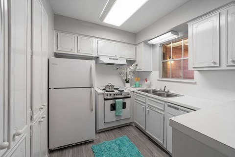 a white kitchen with white appliances and white cabinets