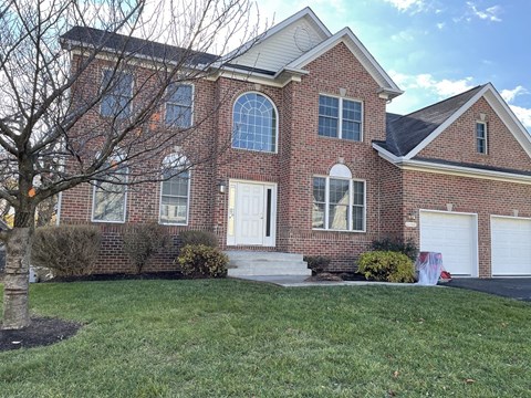 A red brick house with a white garage door.