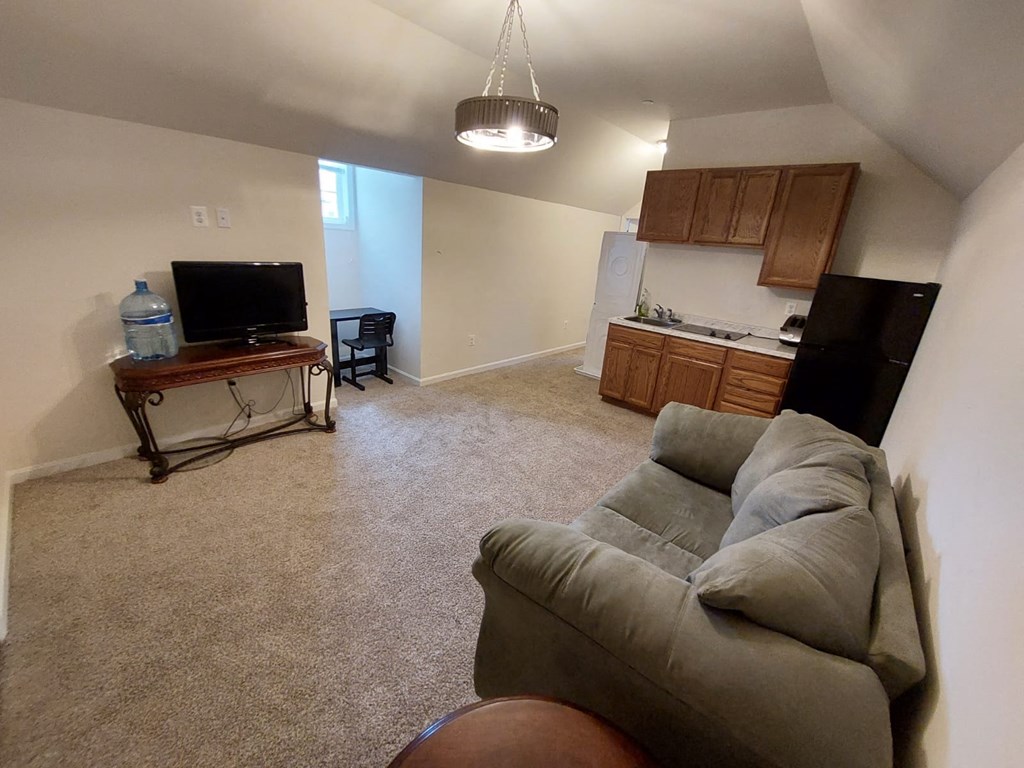 A living room with a grey couch and a television.