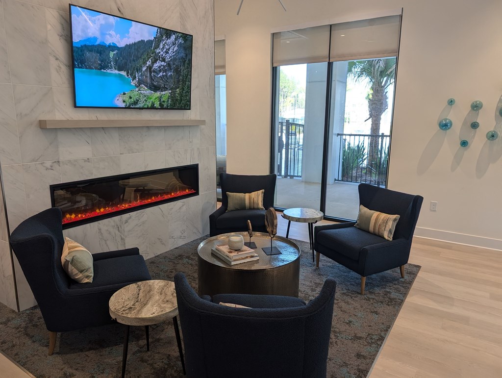 A living room with a fireplace and a television on the wall.