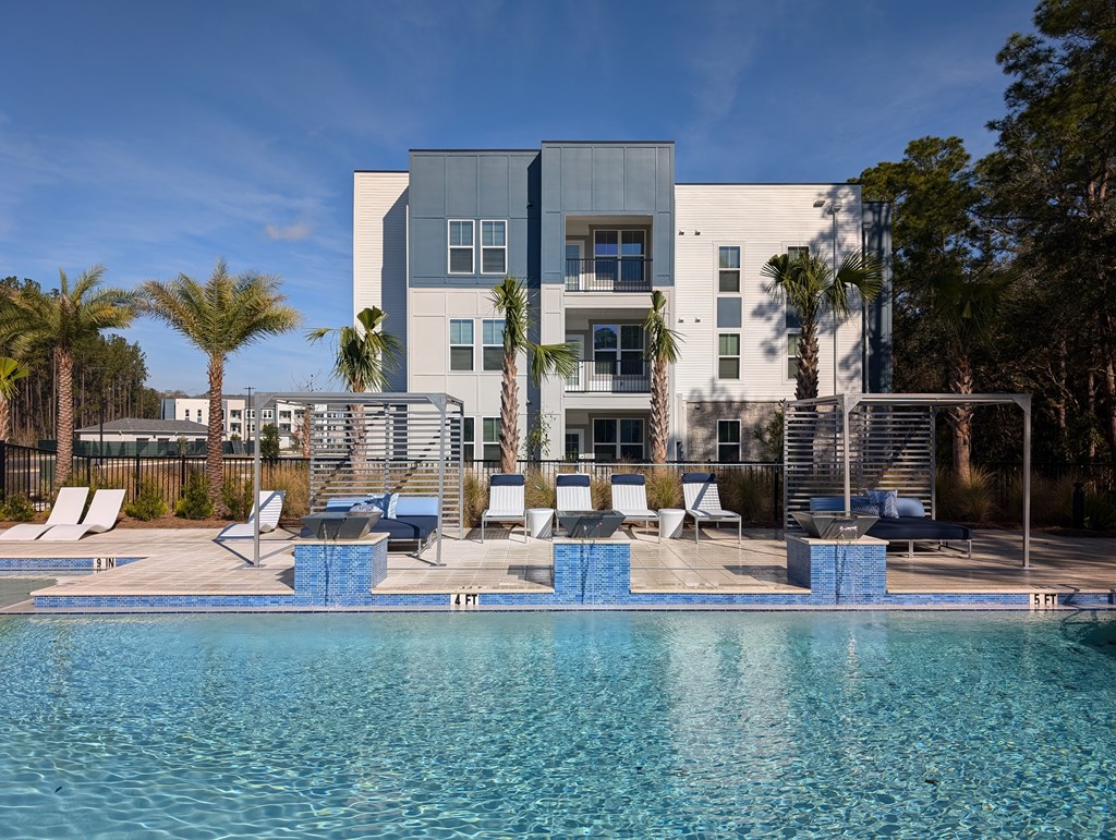 A modern building with a pool in front.