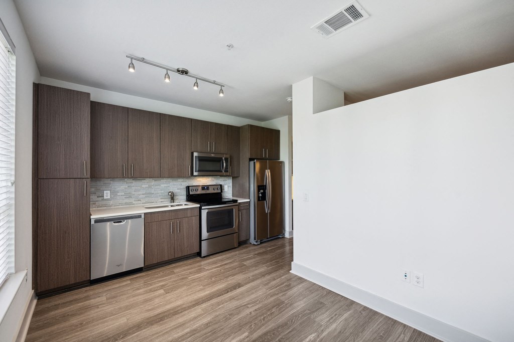 a kitchen with wooden cabinets and stainless steel appliances