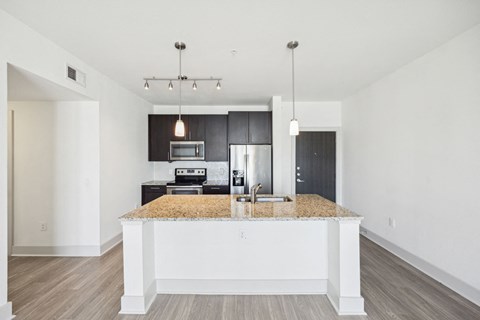 a white kitchen with a granite counter top and