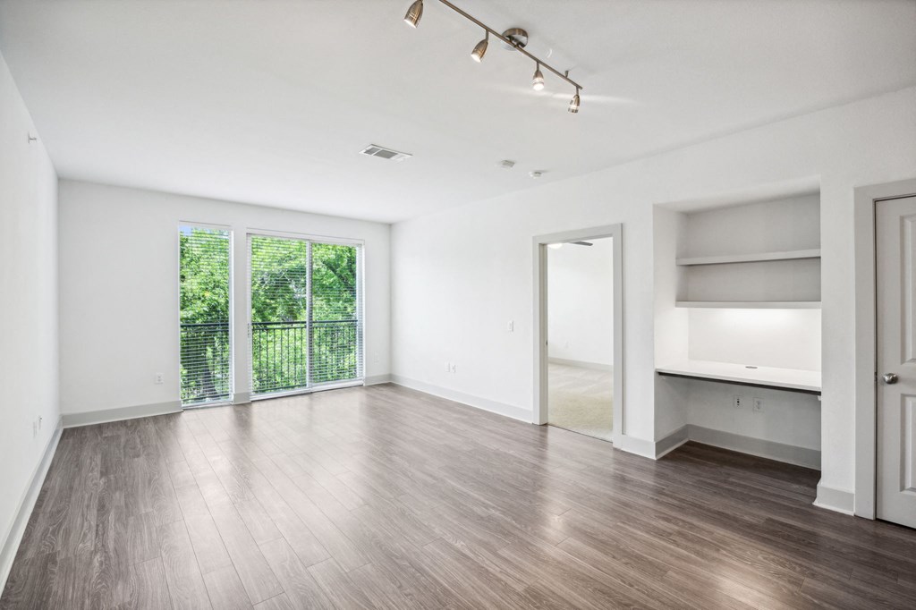an empty living room with white walls and wood flooring