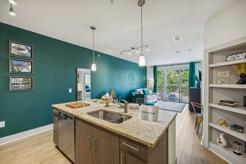 a kitchen with an island and a living room with a sliding glass door