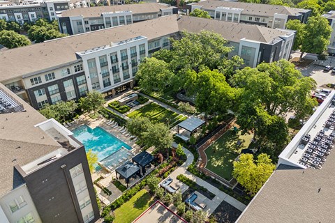 an aerial view of the courtyard of a building with trees and a pool