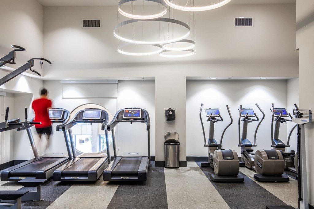a woman running on the treadmill in a gym with cardio equipment