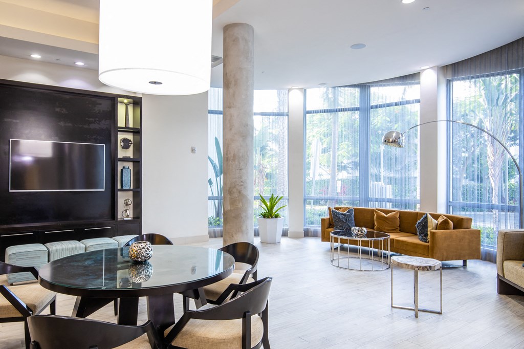 a living room with a large tv and a table and chairs