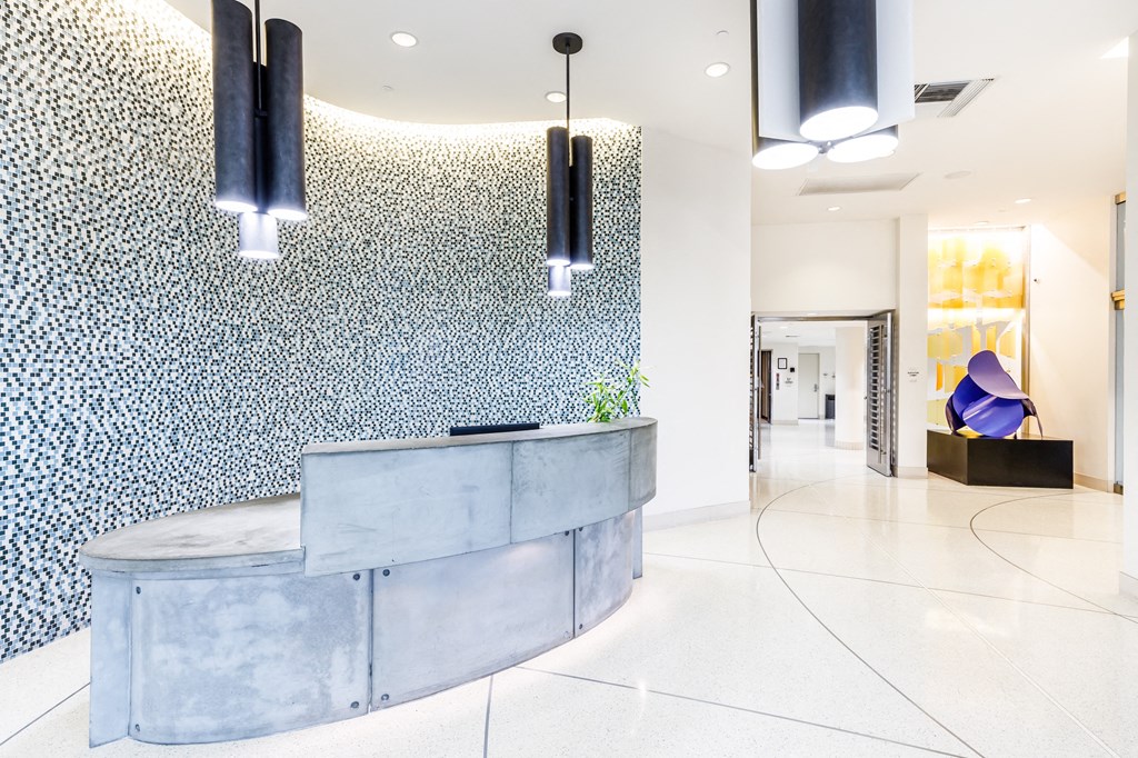 a reception desk in a hotel lobby with a blue and white speckled wall