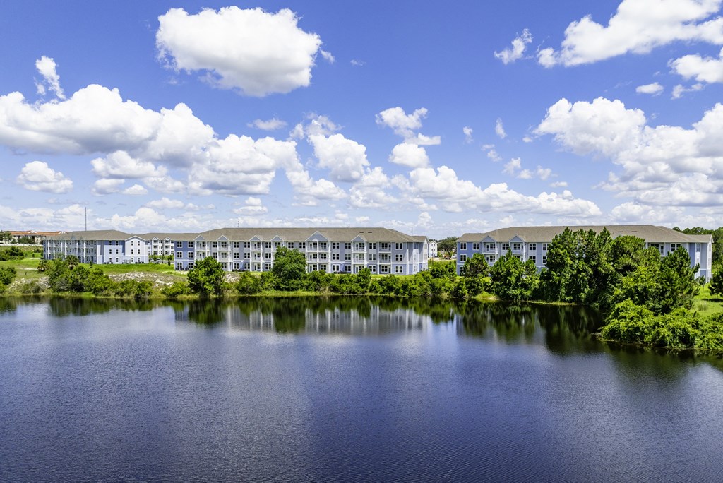 an apartment building overlooking a lake on a sunny day