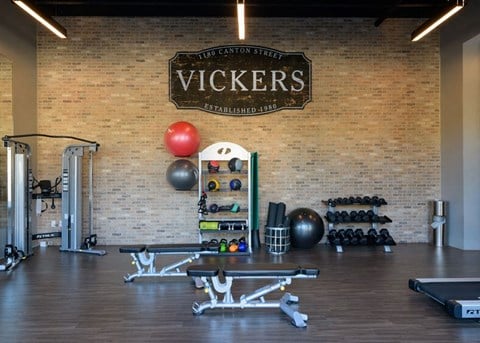 a home gym with a brick wall and a wooden sign that says vices