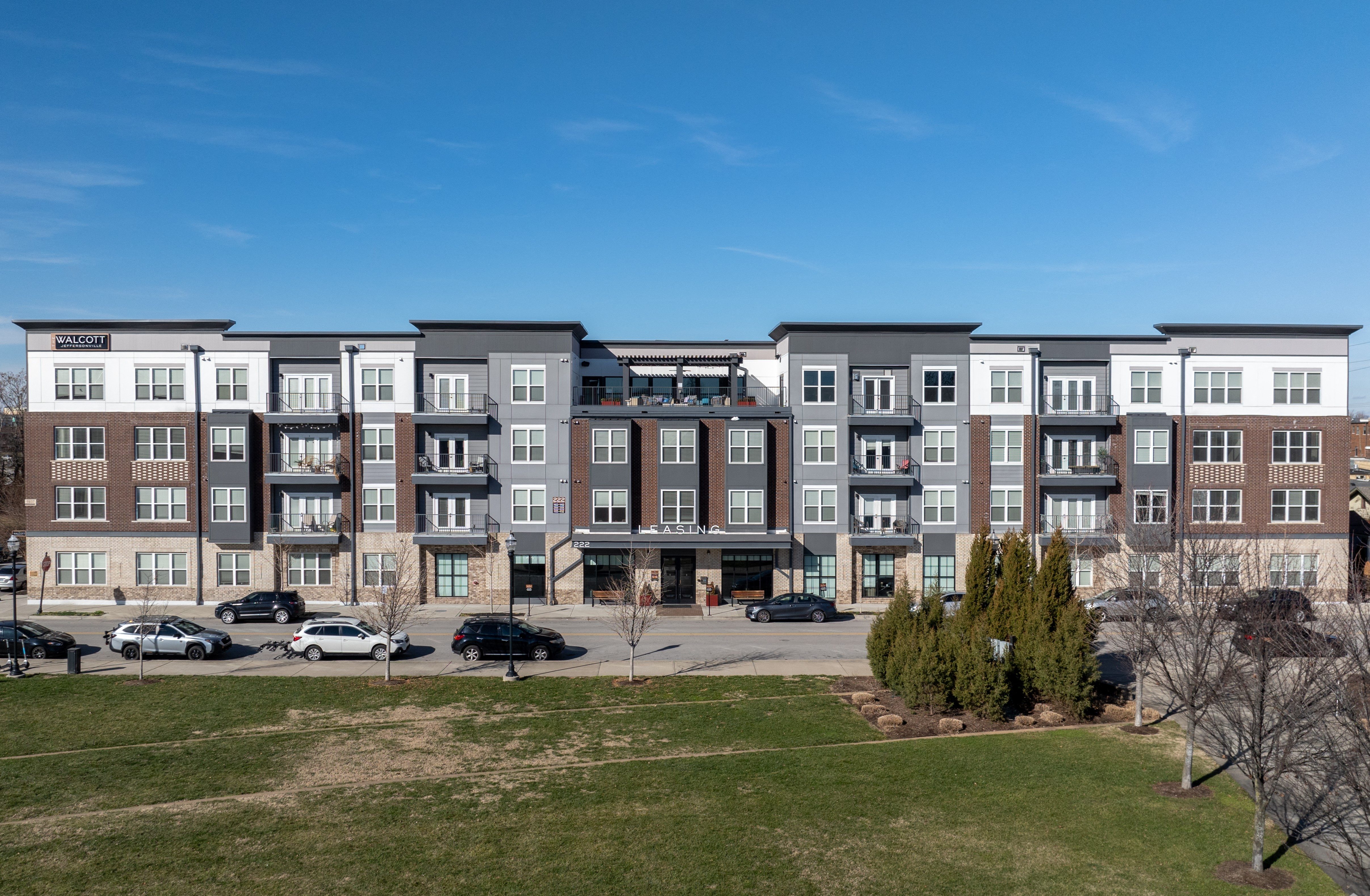 an image of an apartment building overlooking a parking lot