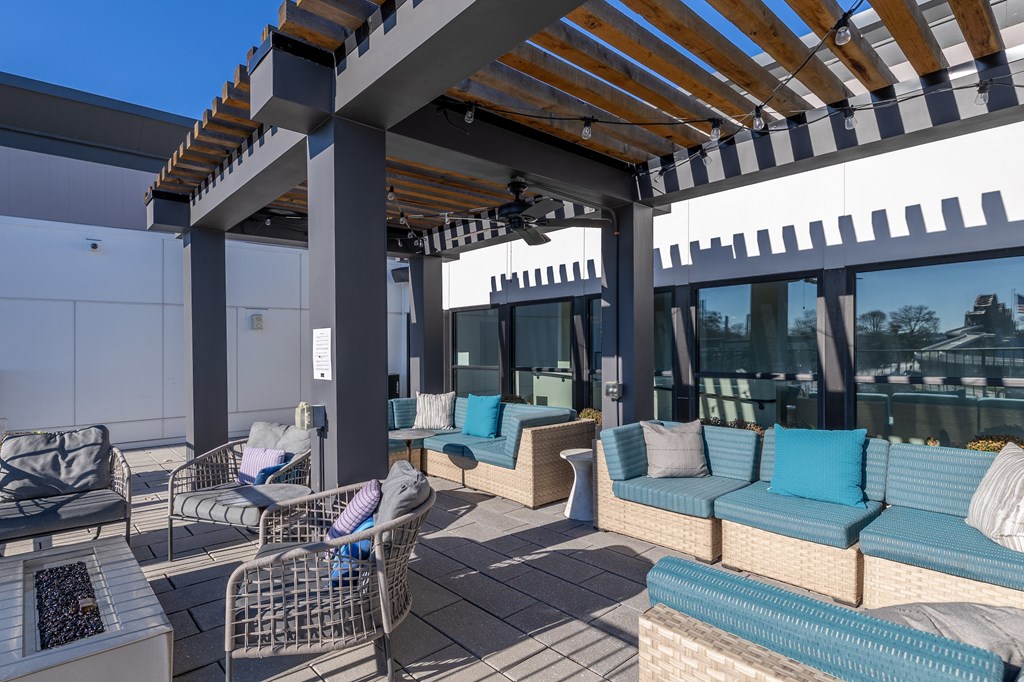 a patio with couches and chairs and a pergola