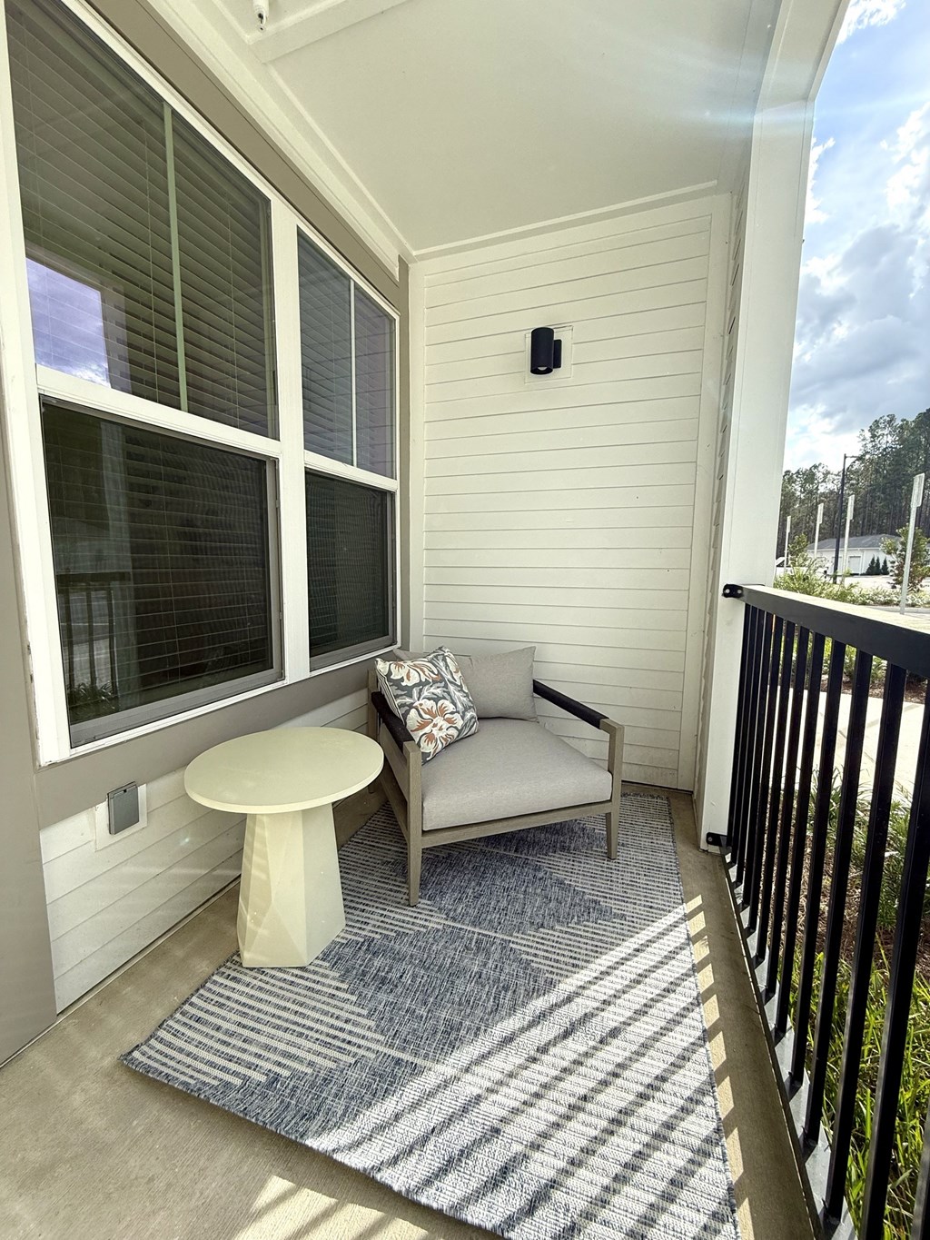 A small balcony with a white table and a sofa.