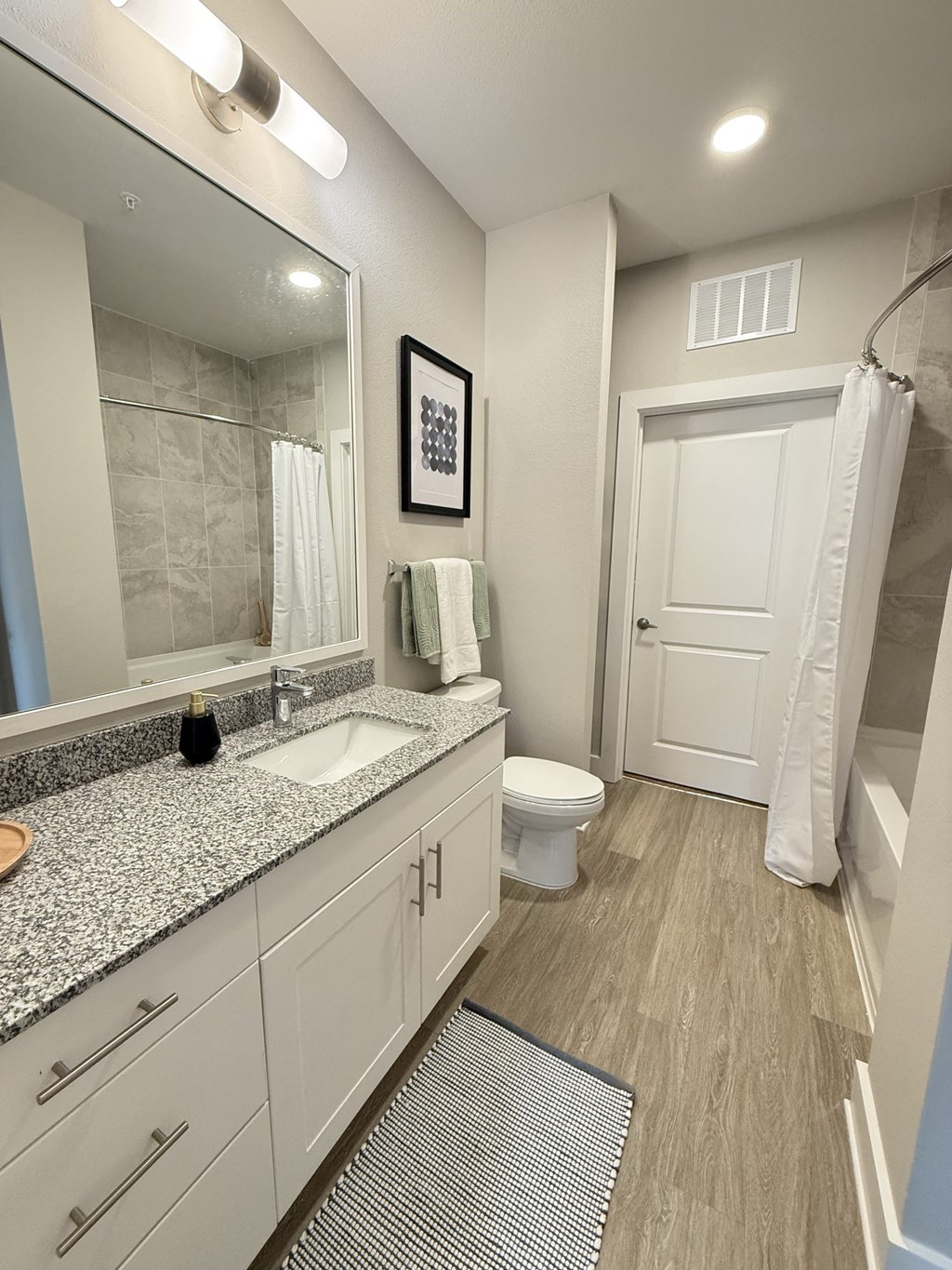 A bathroom with a toilet, sink, and mirror.