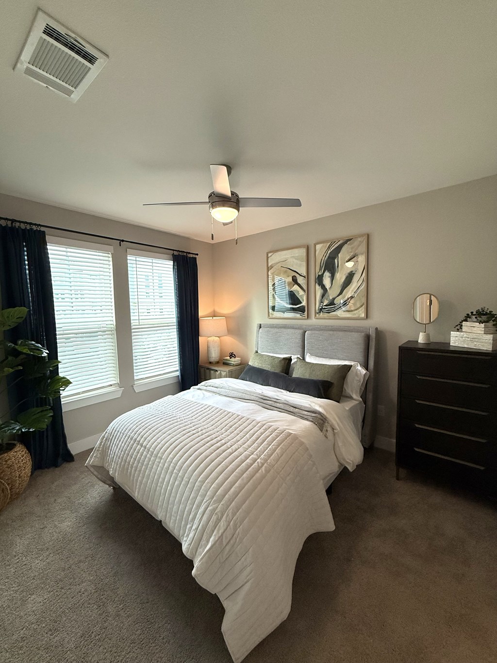 A bedroom with a large bed and a ceiling fan.