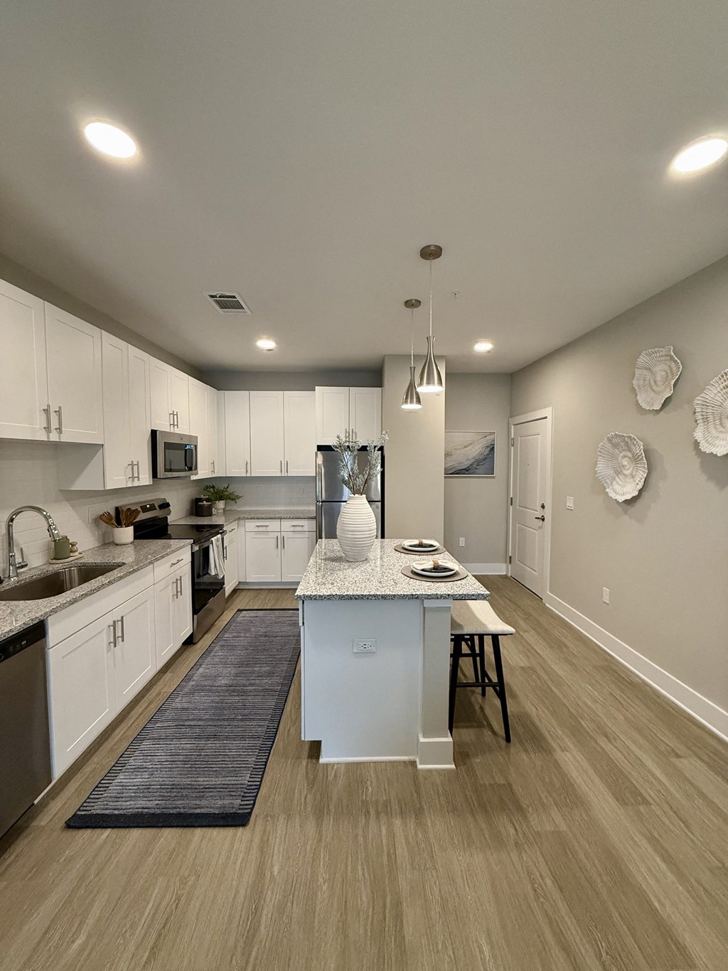 A modern kitchen with white cabinets and a center island.